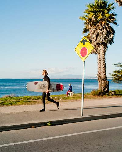tree man holding surfboard near beach pleasure point park